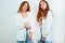 Two redheaded young women both look stylish wearing casual denim with shirt standing on isolated white backgroung