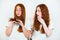 Two redheaded young women standing on isolated white backgroung one is checking her split ends while another looks upset, style