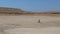 Two researchers, a man and a woman, stand in the middle of the desert where there once was a lake. CRIMEA 2019