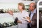 Two retirees together choosing pair of shoes in fashion store