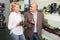 Two retirees together choosing pair of shoes for men in shoe store