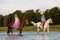 Two riders on horseback at sunset on the beach. Lovers ride horseback. Young beautiful man and woman with a horses at the sea.