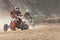 Two riders on a quad bike in the dust race