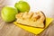 Two ripe apples, piece of apple pie on paper napkin on wooden table