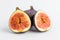 Two ripe organic figs displayed on a white plate on a table, close up of healthy vegan food photographed with soft focus