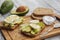 two ripe sliced tasty avocado sandwiches with egg and spices on a wooden Board. Concept of Keto diet