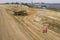 Two road construction workers in orange vests and protective helmets in the middle on the field