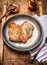 Two roasted pork steaks on rustic metal plate on wooden background
