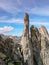 Two rock climbers sitting atop a sharp rock needle in the Val Bregaglia