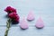 Two roses with three menstrual cups on table