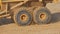 Two rotating wheels of a quarry dump truck with flying pieces of dirt