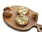 Two Rounded Slices of Bread with Butter, two baked potatoes and a dry white rose on a Wooden Chopboard