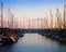 Two rows of boats on pier in the evening