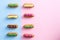 Two rows of colorfully decorated eclairs.