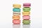 Two rows of sweet multicolored French macaroons of different flavors on white background.