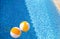 Two rubber air yellow white inflatable balls and toy for swimming pool in transparent blue water. Beach balls floating on water.