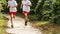 Two runners in white shirts and red shorts in the woods