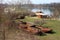 Two rusted river barges and other equipment next to river