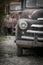 Two rusty vintage trucks in Junk yard .