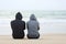 Two sad teenagers sitting on the beach