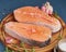 Two salmon steaks, fish fillet, large sliced portions  on a chopping board on dark table. Side view