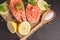 Two salmon steaks with lemon, pepper and salt. View from above.