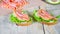 Two sandwiches with salmon, green salad and avocado closeup