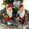 Two santa claus figurine and mini christmas trees