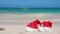Two Santa Claus Hat on sandy beach. Tropical New year celebration