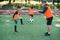 Two school boys have intense soccer training with the coach during football summer camp.