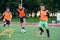 Two school boys are running ladder drills on the turf during football summer camp. Intense soccer training with coach.