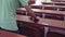 Two school janitors cleaning wooden desks of a empty university classroom