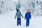 Two school kid boy walking in snowy winter forest. Happy children having fun outdoors in winter. Family, siblings and