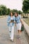 Two schoolgirls are holding a tablet in their hands and watching a video, laughing on the way to school. Friends