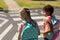 Two schoolgirls looking for traffic while waiting to cross the road