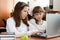 Two schoolgirls performs task using notebook