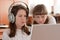 Two schoolgirls performs task using notebook