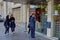 Two schoolgirls are waiting in line to use street ATM.