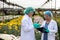 Two Scientist women with head cap and gloves holding lab sheet of flower and researching Chrysanthemums
