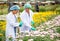 Two scientist women work together in experimental field of flower garden, one woman check the product and the other one record