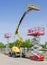 Two scissor and one articulated boom lift on asphalt ground