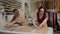 Two seamstresses working with a cloth and a chalk on a table. Female dressmaker uses chalk on the pattern contour on