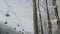 Two-seat cable car on a ski track in the winter snowy forest.