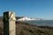 Two seated people admiring view of Seven Sisters chalk cliffs at Hope Gap, Seaford, E. Sussex on the south coast of England UK.