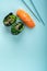 Two seaweed Sushi Chuka and sushi nigiri with salmon with chopsticks on a blue