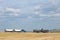 Two semi trucks loading grain in the field.