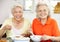 Two Senior Chinese Women Sitting At Home Eating