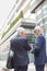 Two senior gray haired businessmen walking down the street and talking, rear view