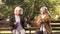 Two senior ladies arguing and sitting on bench in park, grumpy elders, dispute