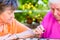 Two senior ladies playing board game in rest home